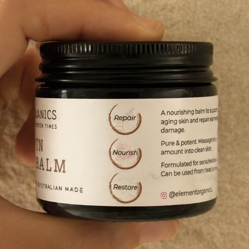 Side view of element organics Golden Tallow Balm in an amber glass jar with a label