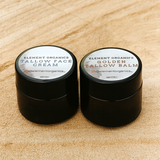 Two small amber jars of Element Organics Tallow Face Cream and Golden Tallow Balm on a sandstone surface.