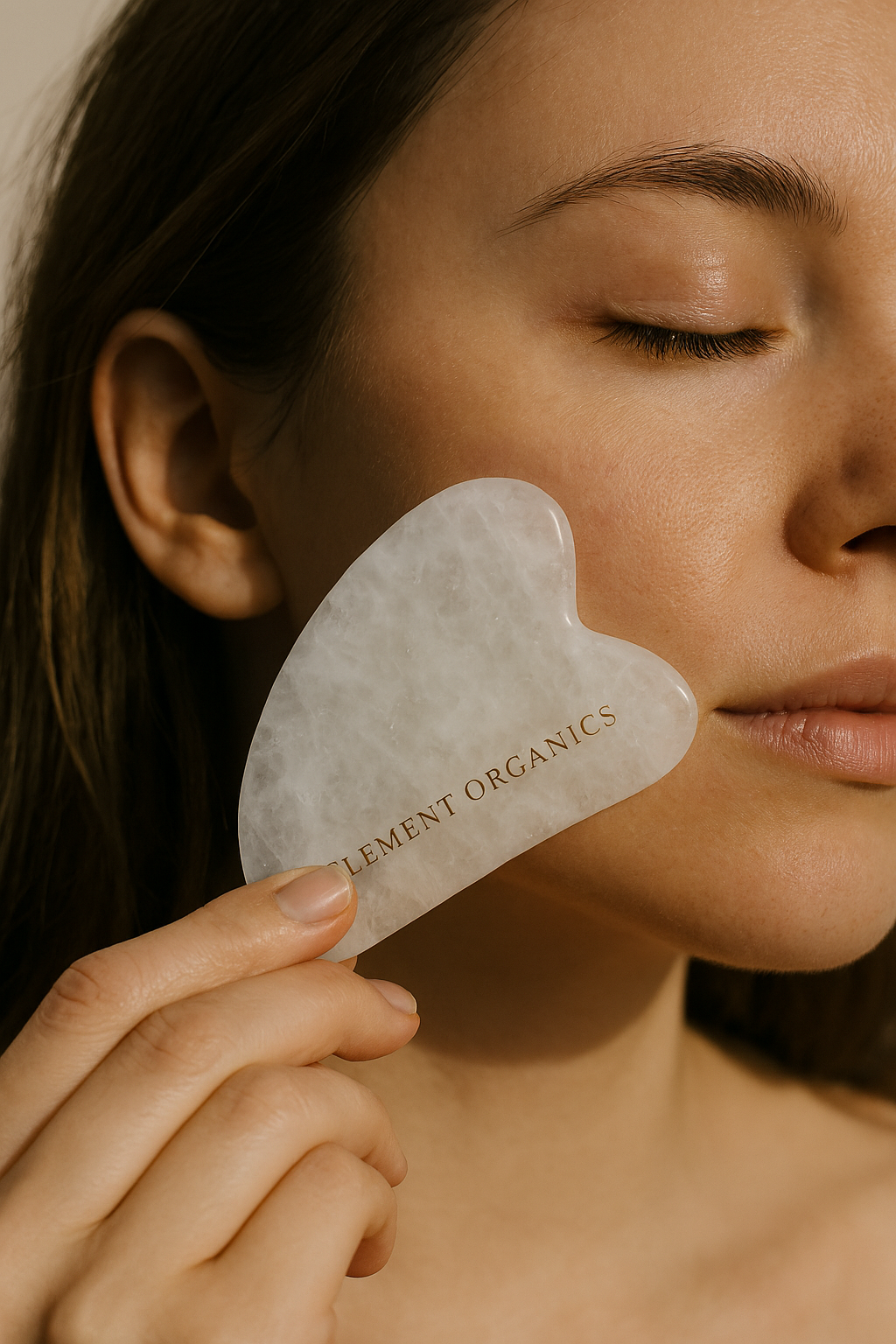 Person using a gua sha tool on their face with 'Element Organics' branding.