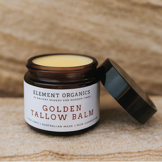 Jar of Golden Tallow Balm with 'Element Organics' label on a sandstone surface